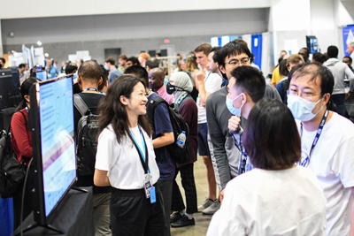 Conference-goers mingle and talk with poster presenters about their work during the JSM 2022 Opening Mixer.