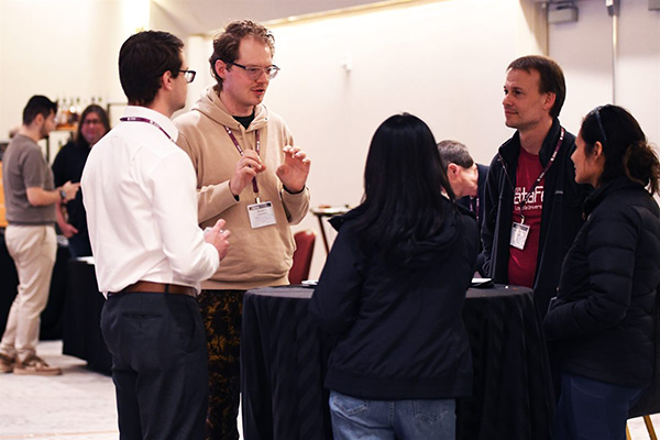 Attendees talking around a high-top table at an SDSS reception