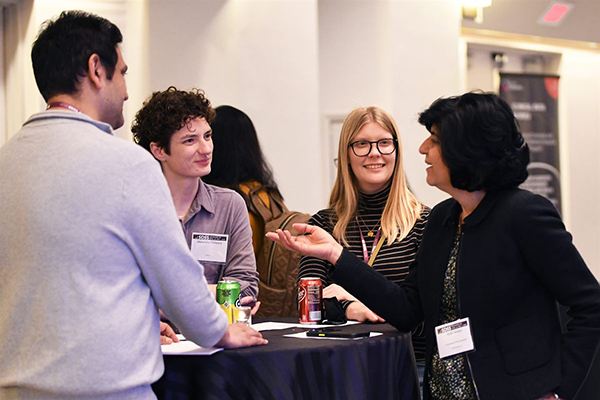 Four SDSS attendees laughing together over drinks